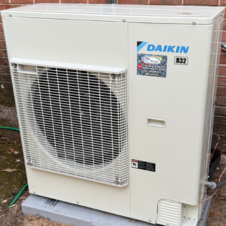 manifold gauge in front of a green propane tank